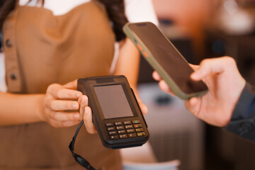 An Asian woman, a skilled female barista,makes coffee while opening her coffee shop.carefully prepares the perfect brew,providing excellent coffee preparation service in a welcoming cafe environment