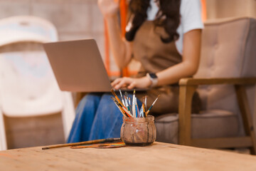 A cute Asian woman, a creative painter, works in her art studio.focuses on her painting,expressing her emotions and ideas through vibrant colors,creating beautiful artwork in a peaceful environment