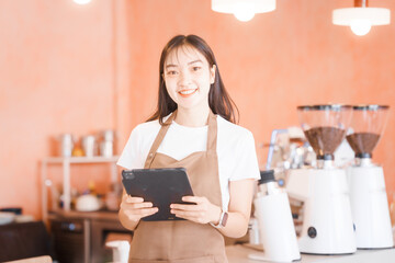 An Asian woman, a skilled female barista,makes coffee while opening her coffee shop.carefully...