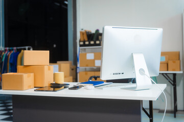 A workspace with a desk, tablet, and computer PC, used by an SME business owner managing an online...