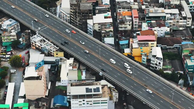 Aerial view of Si Rat Expressway passing over low-rise buildings in Pathum Wan district of Bangkok. 4k cinematic drone footage