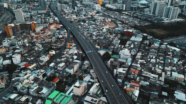Aerial view of Si Rat Expressway passing over low-rise buildings in Pathum Wan district of Bangkok. 4k cinematic drone footage