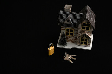 Miniature wooden house, padlock, and keys symbolizing home security and protection against burglary