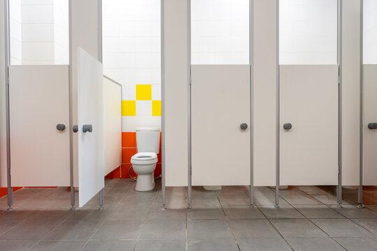 Clean public restroom with separate stalls and colorful wall design in a modern building