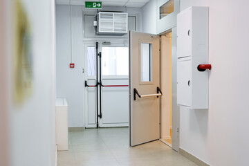 Interior corridor with an open door leading to an exit in a modern building