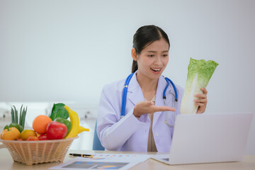 A female nutritionist holds a stethoscope to examine her health. She smiles and promotes healthy...