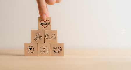 Empathy concept. Wooden blocks with empathy icons on minimal background and copy space. The power...