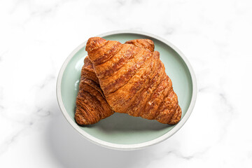 Croissants on a plate on white marble background
