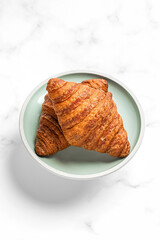 Croissants on a plate on white marble background