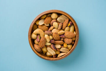 Mixed nuts consisting of cashews, hazelnuts, almonds and pistachios in a wooden bowl