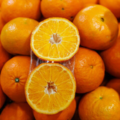 Close-up of freshly harvested oranges, showcasing a vibrant display of whole fruits and a halved orange revealing juicy, succulent segments, symbolizing freshness, health, and natural sweetness