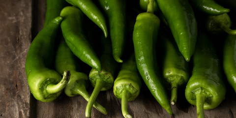 Fresh raw green peppers on table, genuine food ingredients, agricultural concept
