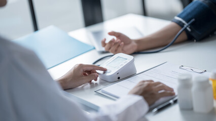 Medical Examination Doctor Conducting Blood Pressure Test on Patient for Diagnosisใ