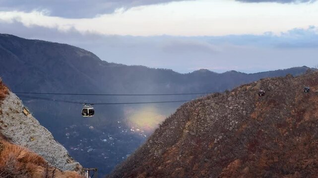 A cable car gliding over scenic Owakudani Hakone mountains with cloudy skies