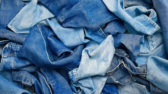 Denim fabric pile showcasing various shades of blue in a casual textile environment