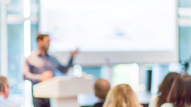 Professional Training Event – A blurred background of a professional training event with a focused presenter.
