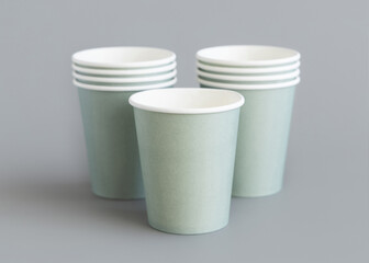 Light green paper disposable cup closeup on grey. Eco friendly, zero plastic tableware