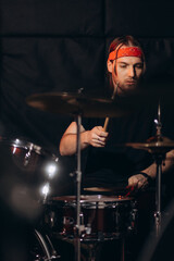 Drummer rehearsing on drums before rock concert. Man recording music on drum set in studio