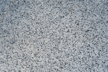 Granite surface with a speckled texture illuminated by natural light during daylight hours