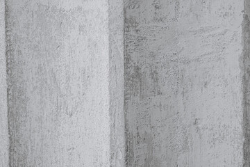 Textured concrete wall with varying shades of gray during daylight