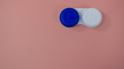 Contact lens container or case. For cleaning solution. On light pink color background. Copy space