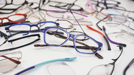 Assortment of broken glasses, broken hinges, missing lenses, cracked frames, deformed glasses. Mix...
