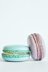Two colorful French Macarons, cakes with different flavors, mint, apple, currant flavor. dessert, macaroons aquamarine, green, purple color. Copy space for text, close up
