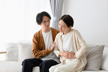体調不良の女性と気遣う男性