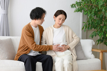 体調不良の女性と気遣う男性