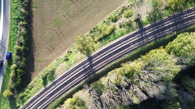 Vid&eacute;o drone voix de chemin de fer et route au milieu de la campagne dans la nature pour illustrer les infrastructures routi&egrave;res en r&eacute;gion