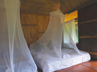 white mosquito net for insect protection at vintage bedroom resort.