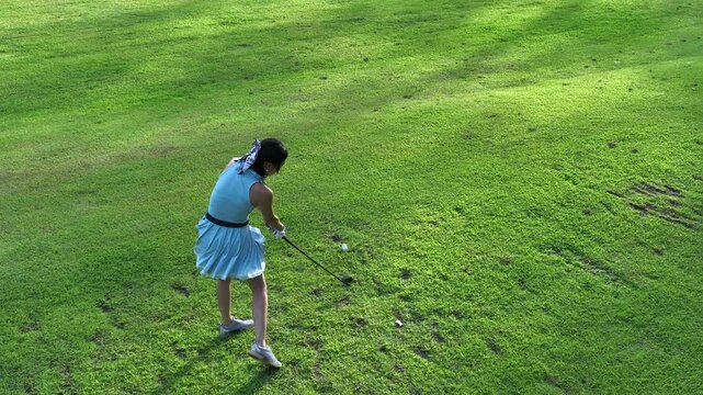 Aerial view asian girl play golf on green golf course, Woman golf player swing golf club, Asian girl golf player, People lifestyle.