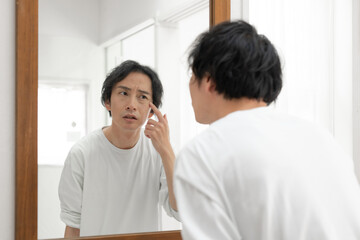 鏡の前で悩む男性