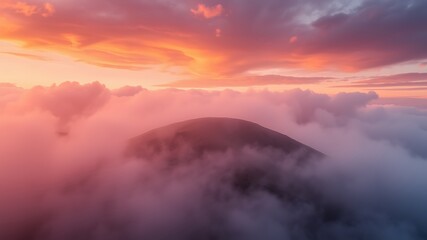 Obraz premium Serene mountain peak enveloped in a breathtaking sunset, showcasing vibrant clouds and a misty atmosphere.