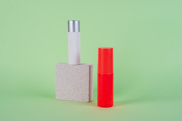 Cosmetic red bottle and hand, bottle, lotion or serum with stylish props on green background. 