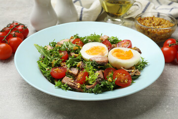 Delicious fresh tuna salad on grey textured table, closeup