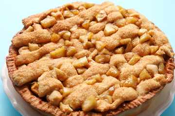 Tasty homemade apple pie on light blue background, closeup