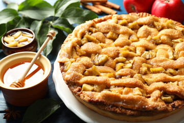 Homemade apple pie and ingredients on blue wooden table, closeup