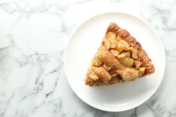 Slice of homemade apple pie on white marble table, top view. Space for text