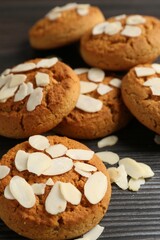 Tasty cookies with almond flakes on wooden table, closeup