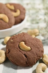 Tasty chocolate cookies with cashew on table, closeup