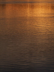 Water reflection of a sun set in Rhine River near Stein am Rhein in Switzerland - vertical