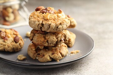 Tasty cookies with nuts on gray textured table, closeup