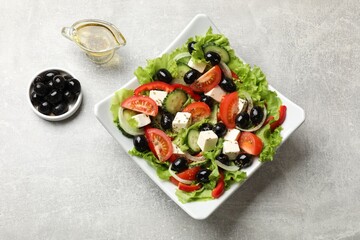 Delicious fresh Greek salad on grey table, top view