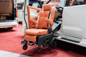 Brown electric wheelchair mounted on white suv car