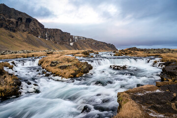 Panoramic view of the cliff and flowing rushing water on the river in Kirkjubæjarklaustur or...