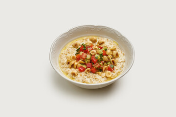 A fresh and healthy breakfast of oatmeal topped with a vibrant mix of diced tomatoes, avocado, and crunchy nuts.