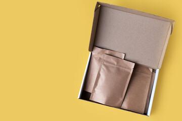 Kraft brown paper empty bags isolated mock up on yellow background. Eco friendly pack with zipper, roasted specialty coffee beans, tea, snack, alternative sample trendy concept. top view, flat lay