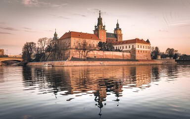Fototapeta premium Krakow's Wawel Castle, Poland Wawel Castle reflected in calm river at sunset.