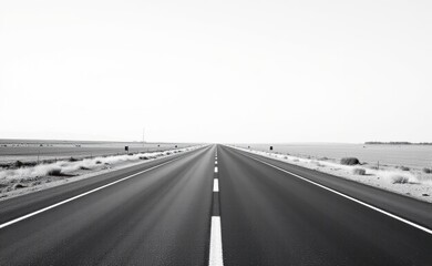 A scenic road winds through a dramatic desert landscape, with towering red rock cliffs and a clear blue sky in the background.